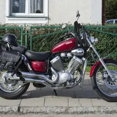Czerwony motocykl Yamaha Virago 535 z sakwami i kaskiem. Dane techniczne tego klasyka są imponujące.