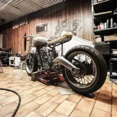 Warsztat z motocyklem na podnośniku. Zastanawiasz się, ile kosztuje przegląd motocykla?