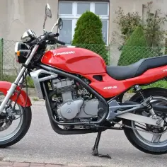 Czerwony motocykl Kawasaki ER-5 Twister stoi na chodniku.