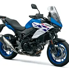 Niebiesko-biały japoński motocykl Suzuki SV-650X z turystyczną owiewką i bagażnikiem, gotowy na przygodę.