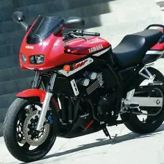Czerwony motocykl Yamaha Fazer 600, z widocznymi detalami silnika i napędu. Idealny do miasta i na trasę, sprawdź yamaha fazer 600 dane techniczne.