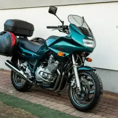 Zielony motocykl Yamaha XJ 900 z kuframi gotowy na podróż.