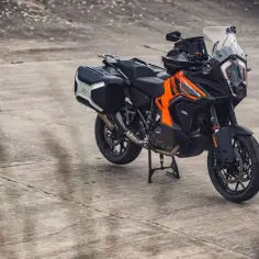 Pomarańczowo-czarny motocykl KTM 1290 Super Adventure z kuframi, gotowy na każdą wyprawę.
