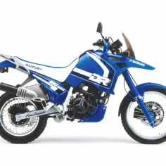 Niebieski motocykl Suzuki DR 800 BIG z białymi akcentami, gotowy na przygodę.