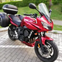 Czerwony motocykl Yamaha FZ6 z kuframi, gotowy na podróż.