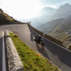 Motocyklista przemierza malownicze trasy motocyklowe w Austrii, pokonując kręte serpentyny górskiej drogi.