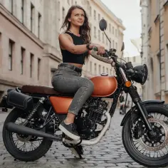 Kobieta na stylowym motocyklu w mieście. Od ilu lat można robić prawo jazdy na motor 125? Od 16 roku życia!