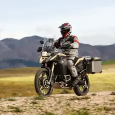 Motocyklista na BMW 800 GS przemierza malowniczą, górską trasę.