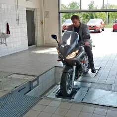 Mężczyzna na motorowerze na stanowisku diagnostycznym. Zastanawiasz się, ile kosztuje przegląd motoroweru?