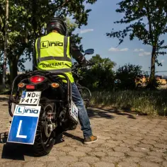 Kursant na motocyklu z literą "L" z przodu, przygotowuje się do egzaminu na prawo jazdy a2.