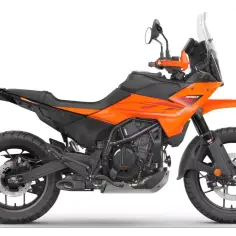 Pomarańczowy motocykl **KTM 390 Adventure** gotowy na każdą trasę, z terenowym bieżnikiem i wysoką szybą.