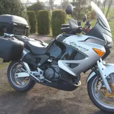 Srebrno-czarny motocykl Honda Varadero 1000 z kuframi, gotowy na podróż. Dane techniczne tego modelu są imponujące.