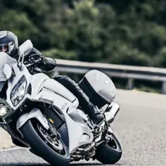 Motocyklista w kasku pochyla się na zakręcie na białym motocyklu Yamaha FJR 1300. Poznaj yamaha fjr 1300 dane techniczne.