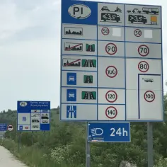 Znaki drogowe w Polsce informują, ile można jechać na autostradzie. Widoczne są ograniczenia prędkości dla różnych pojazdów i informacje o opłatach.