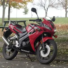Czerwony motocykl Honda CBR 125R na tle jesiennego parku. Poznaj honda cbr 125 dane techniczne.