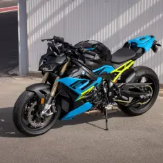 Potężny motocykl BMW S1000R w czarno-niebieskich barwach z żółtym stelażem, gotowy do jazdy po torze.