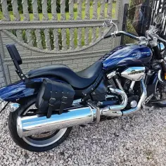 Błękitny Yamaha Warrior 1700 z chromowanymi elementami i sakwami, gotowy na podróż.