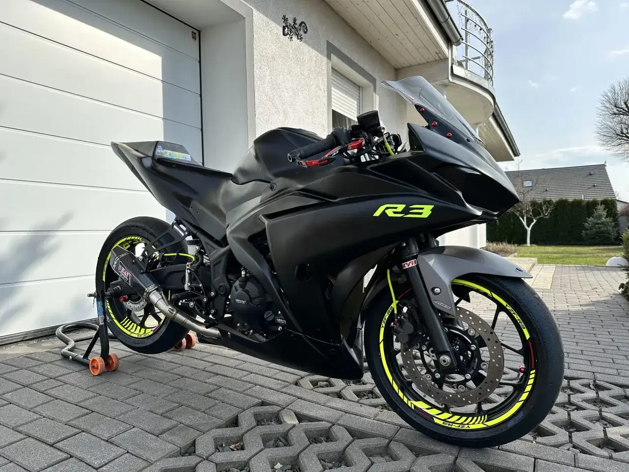 Czarny motocykl Yamaha R3 z żółtymi akcentami, gotowy do jazdy. Poznaj jego yamaha r3 dane techniczne.