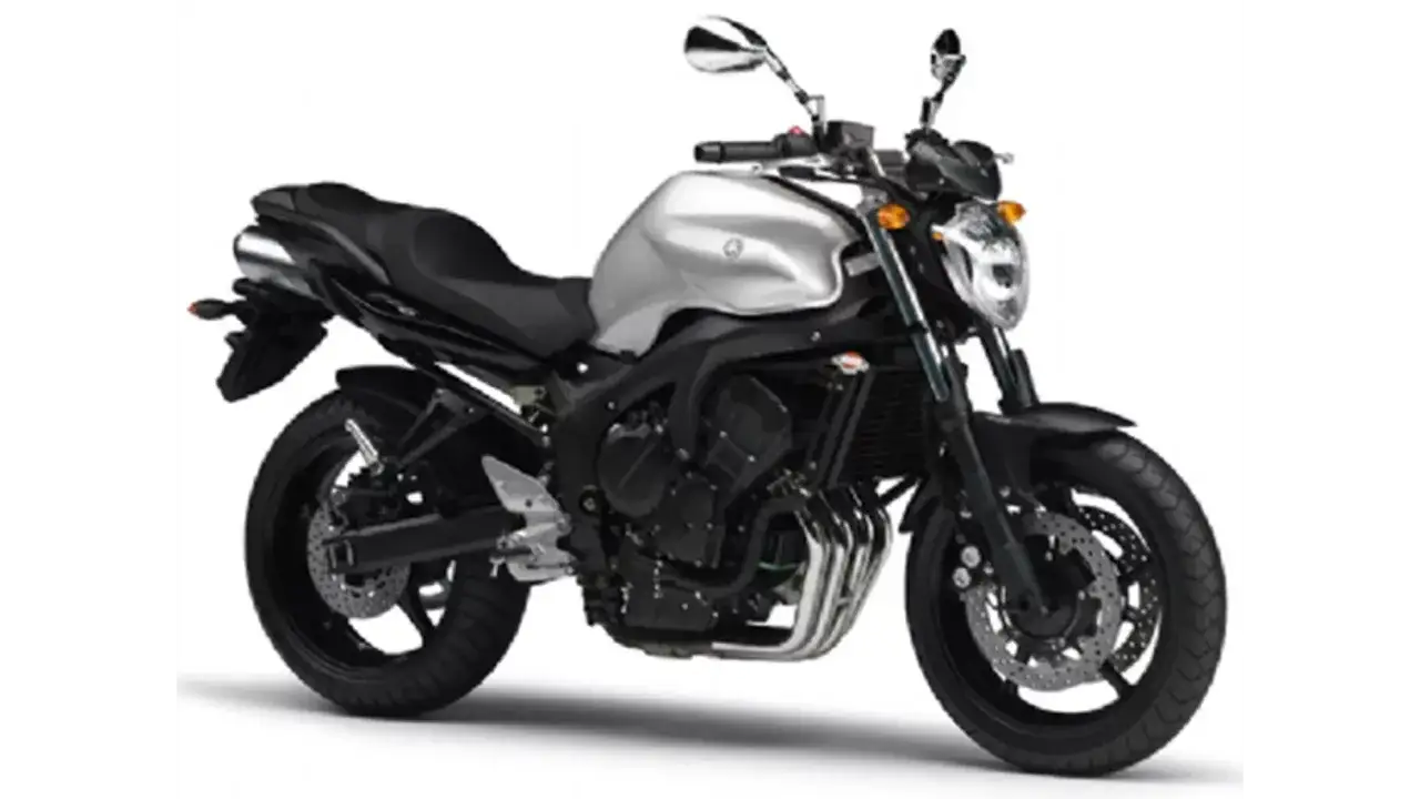 Srebrny motocykl Yamaha FZ6 z czarnym siedzeniem i detalami. Widoczny silnik, wydech i koła.