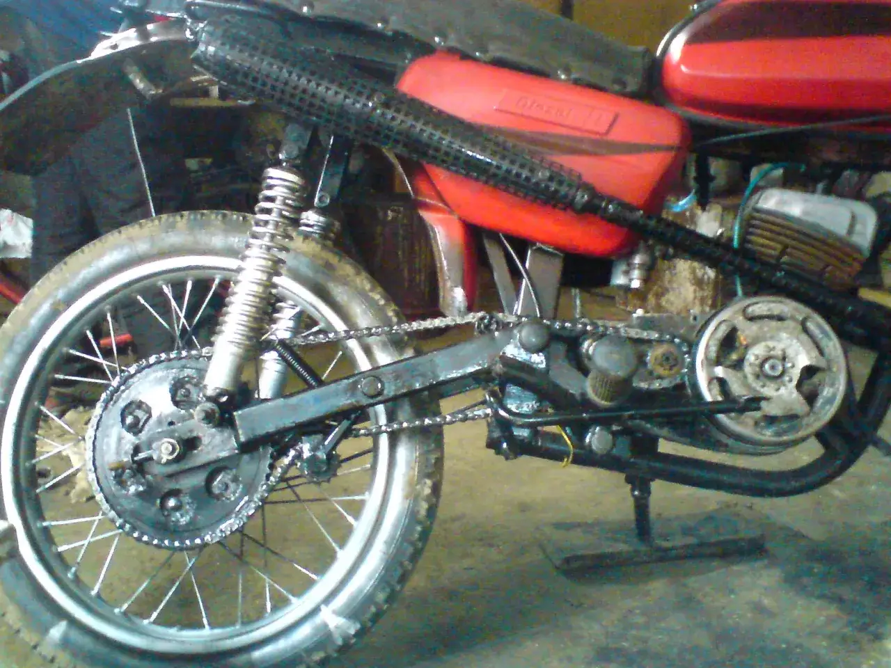 Część motocykla WSK 125, widoczna tylna zębatka, amortyzator i czerwony bak. Ile koni ma ten klasyk?