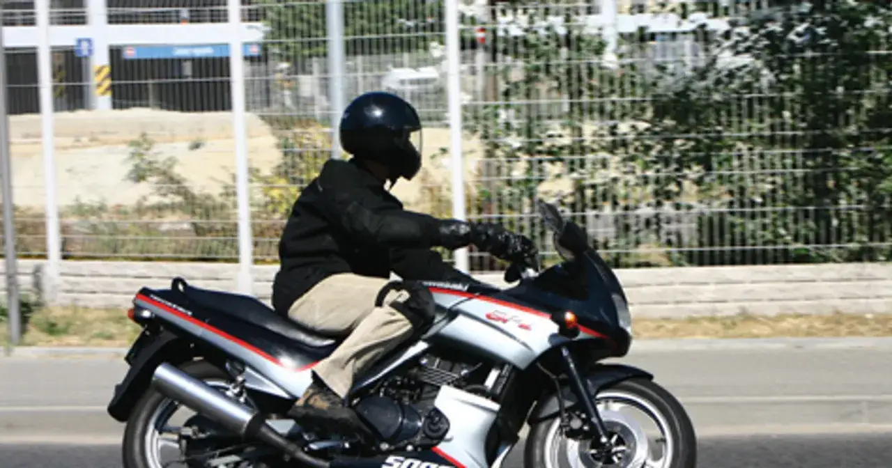 Motocyklista w kasku jedzie na sportowym motocyklu Kawasaki GPZ 500.
