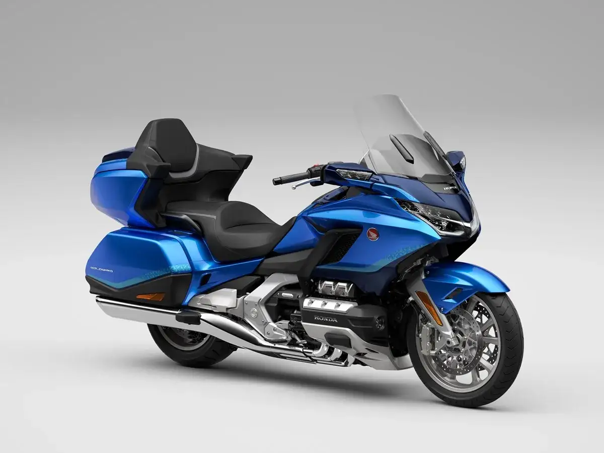 Błękitny motocykl Honda Goldwing z dużym kufrem i wygodnym siedzeniem, gotowy na długie podróże.