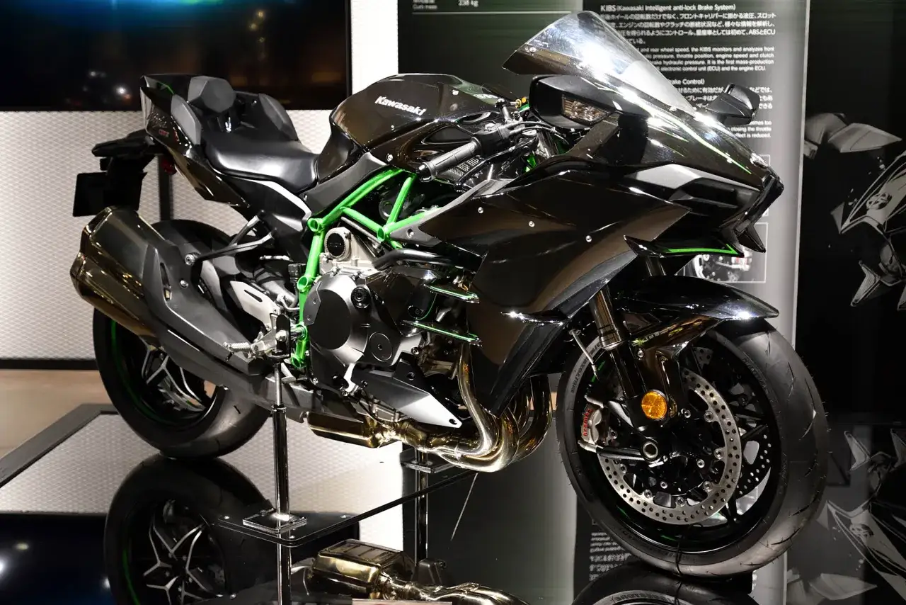 Czarny motocykl Kawasaki H2 z zielonym stelażem, błyszczącymi detalami i sportowym wyglądem.