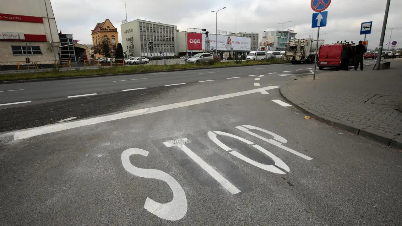 Na drodze widoczna jest linia warunkowego zatrzymania namalowana jako napis 