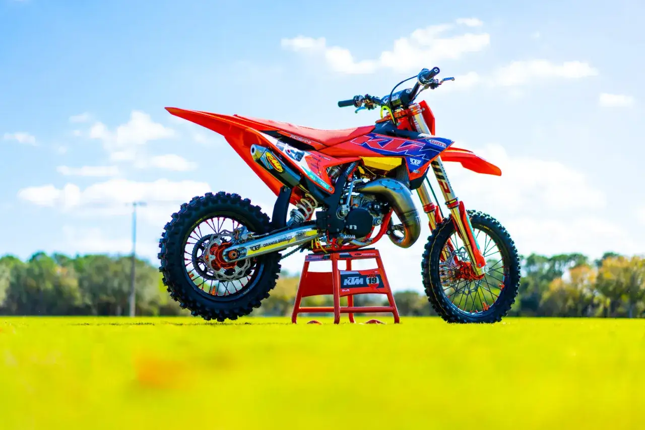 Pomarańczowy KTM SX 85 na stojaku, gotowy do akcji. Zastanawiasz się, ile koni ma ten model?