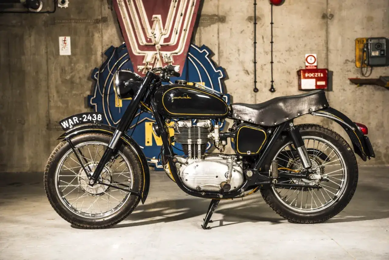 Czarny motocykl mz ts 250 z żółtymi akcentami i tablicą WAR-2438, stojący w garażu.