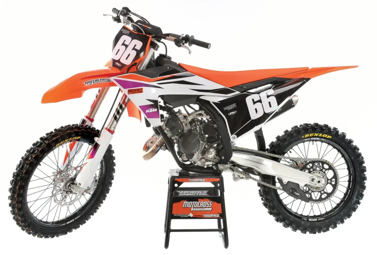 Pomarańczowy KTM SX 125 z numerem 66 na białej tabliczce. Ten motocykl crossowy, choć ma 125cc, potrafi dostarczyć mnóstwo emocji.