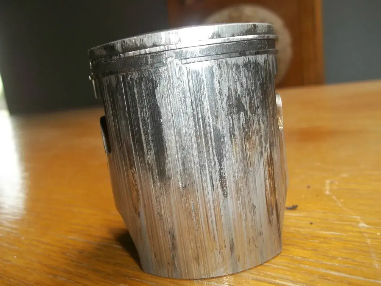Zużyty tłok z widocznymi głębokimi rysami, objawy zatarty silnik.