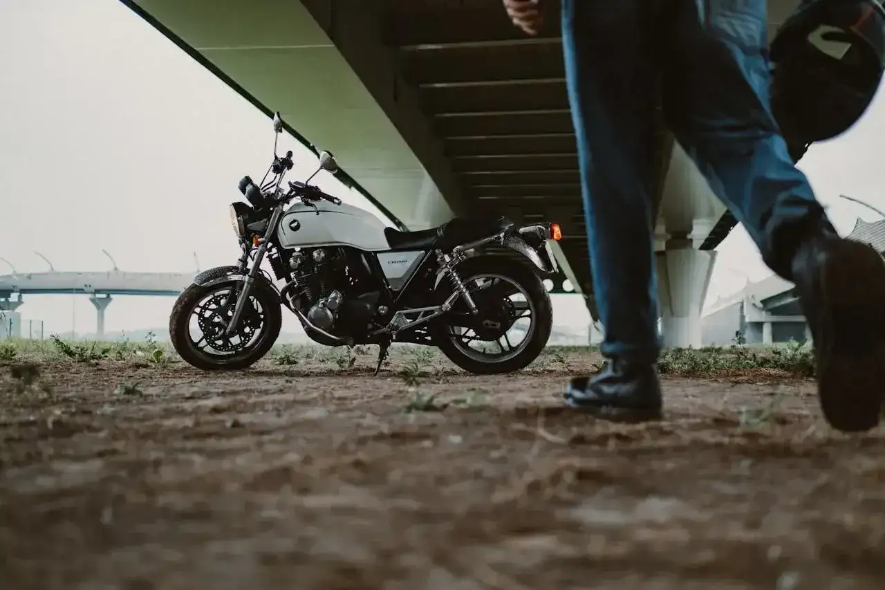 Biały motocykl klasyk, idealny na prawo jazdy kat B. Motocykl 250cc czeka na swojego kierowcę pod mostem.