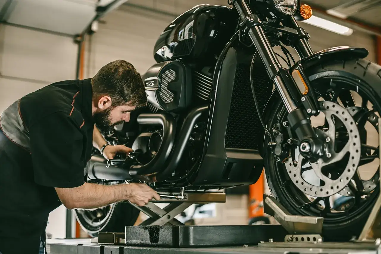 Mechanik sprawdza motocykl, dbając o jego stan techniczny. Pamiętaj o regularnej wymianie oleju, by zapewnić płynną jazdę.