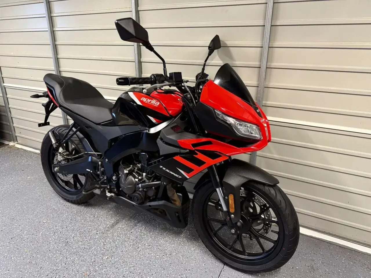 Sportowy motocykl Aprilia RS4 w czerwono-czarnych barwach, gotowy do jazdy.