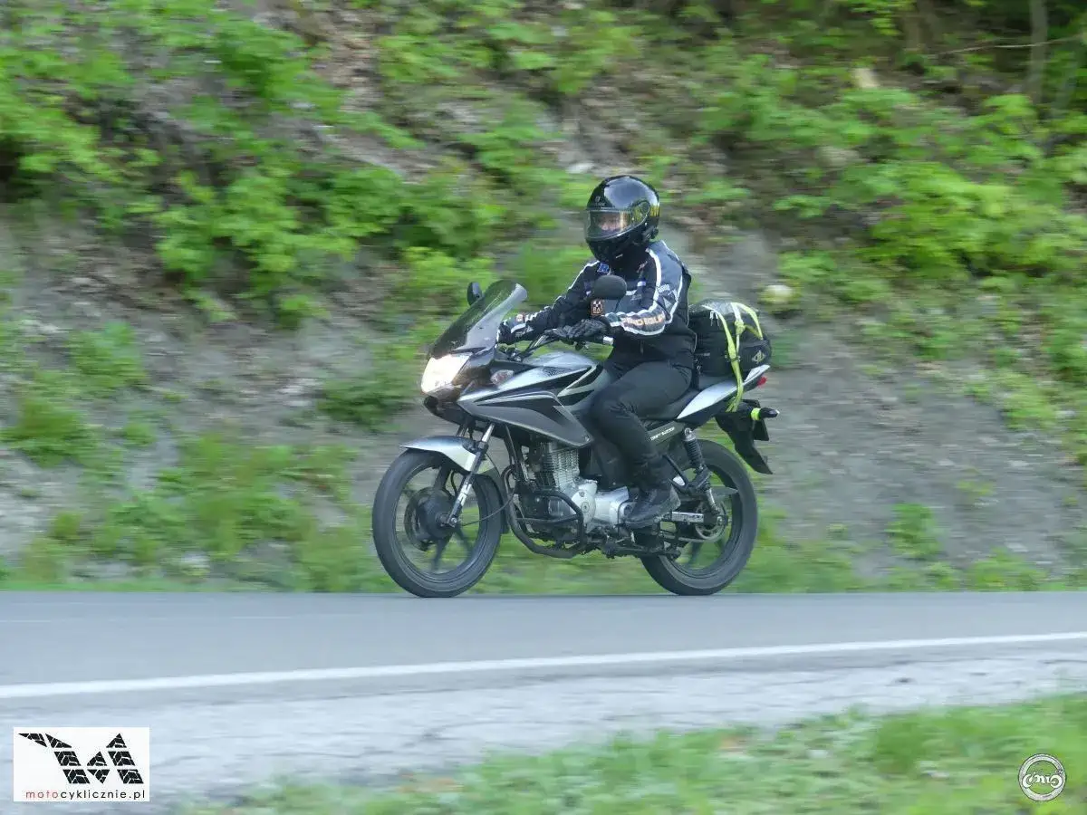 Motocyklista przemierza malowniczą pętlę bieszczadzką, ciesząc się jazdą wśród zielonych wzgórz.