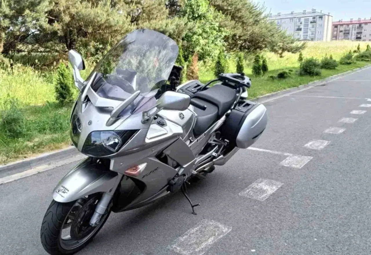 Srebrny motocykl Yamaha FJR 1300 z kuframi, gotowy na podróż. Dane techniczne tego turystycznego potwora zachęcają do odkrywania świata.