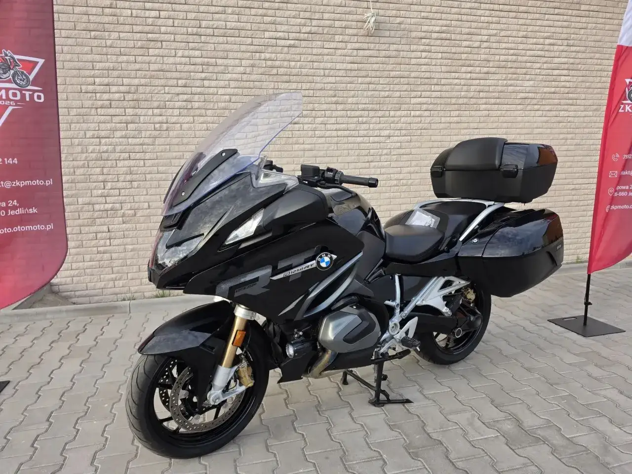 Czarny motocykl BMW R 1250 RT z kuframi, gotowy na dalekie podróże.