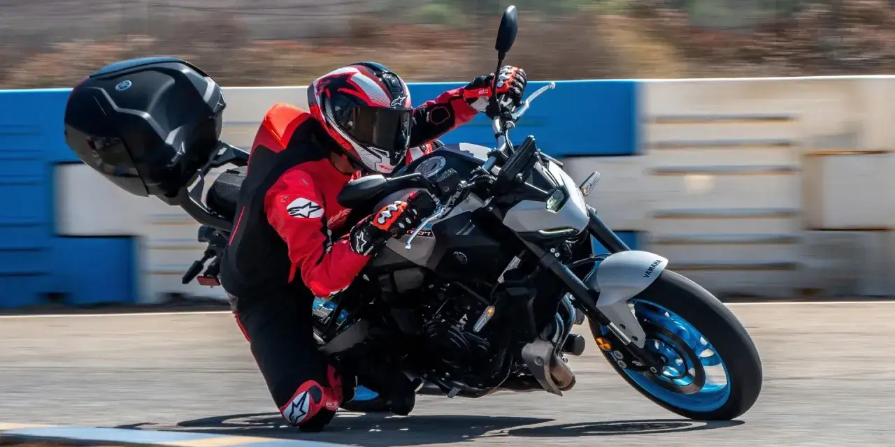 Motocyklista w czerwonym stroju pochyla się na torze na Yamasze MT-07. Poznaj Yamaha MT 07 dane techniczne.