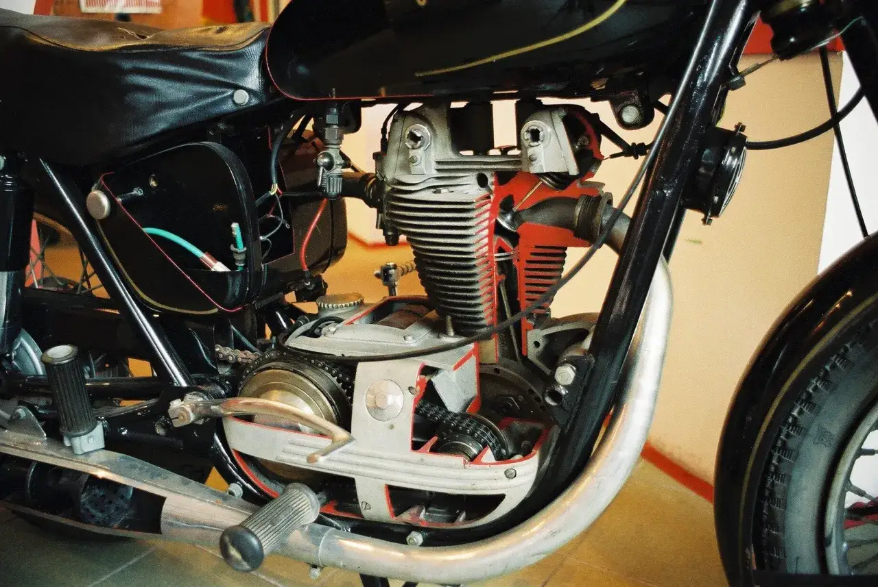 Przekrój silnika motocyklowego dwusuwowego z widocznymi elementami, takimi jak tłok, cylinder i wał korbowy.